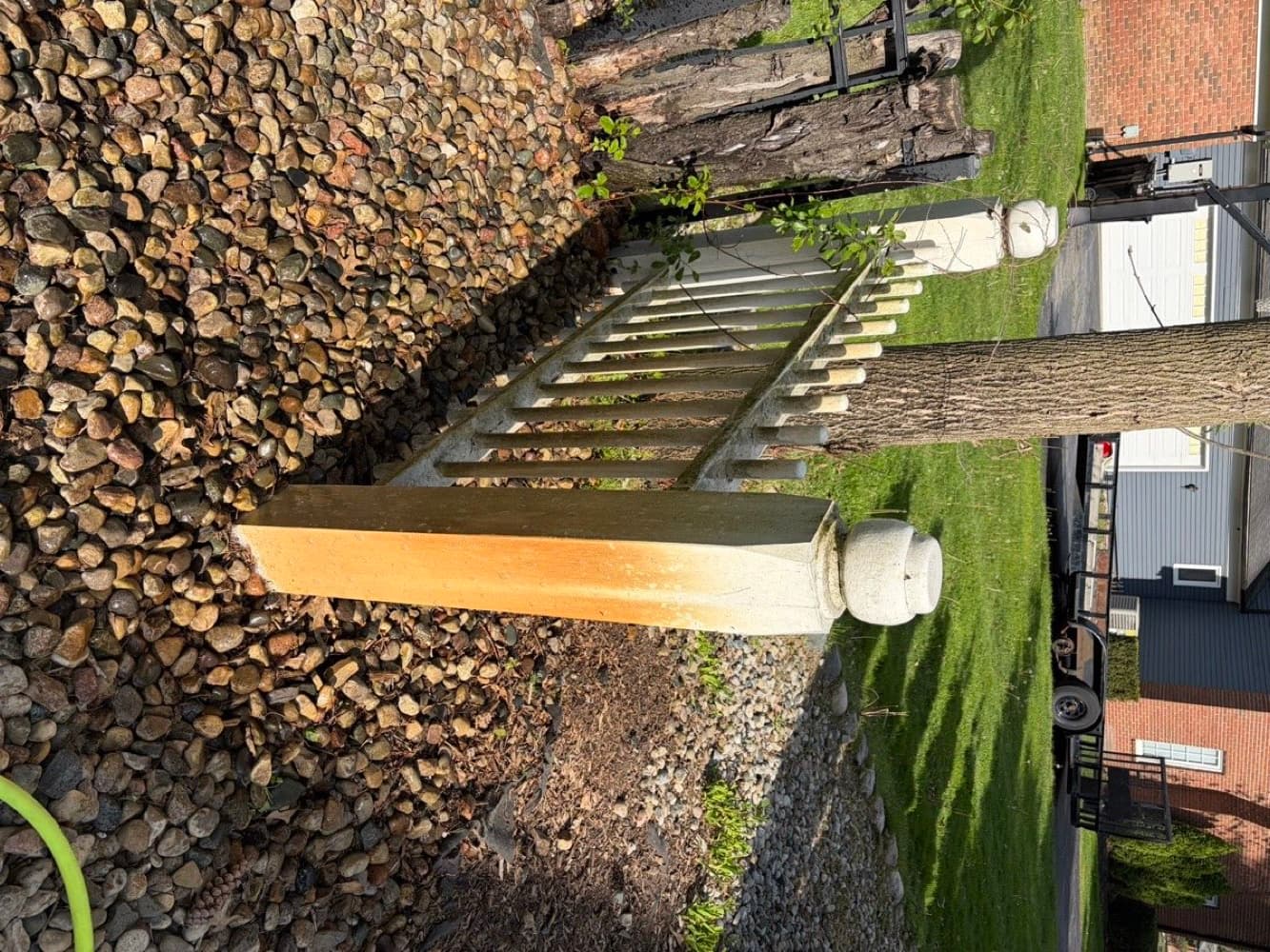 White fence post stained orange with rust and grime before pressure washing