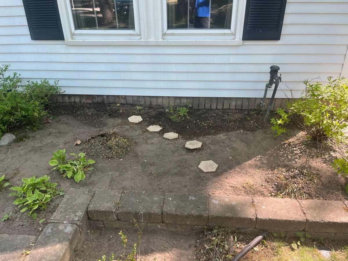 Same garden bed tidy with exposed pavers after cleanup
