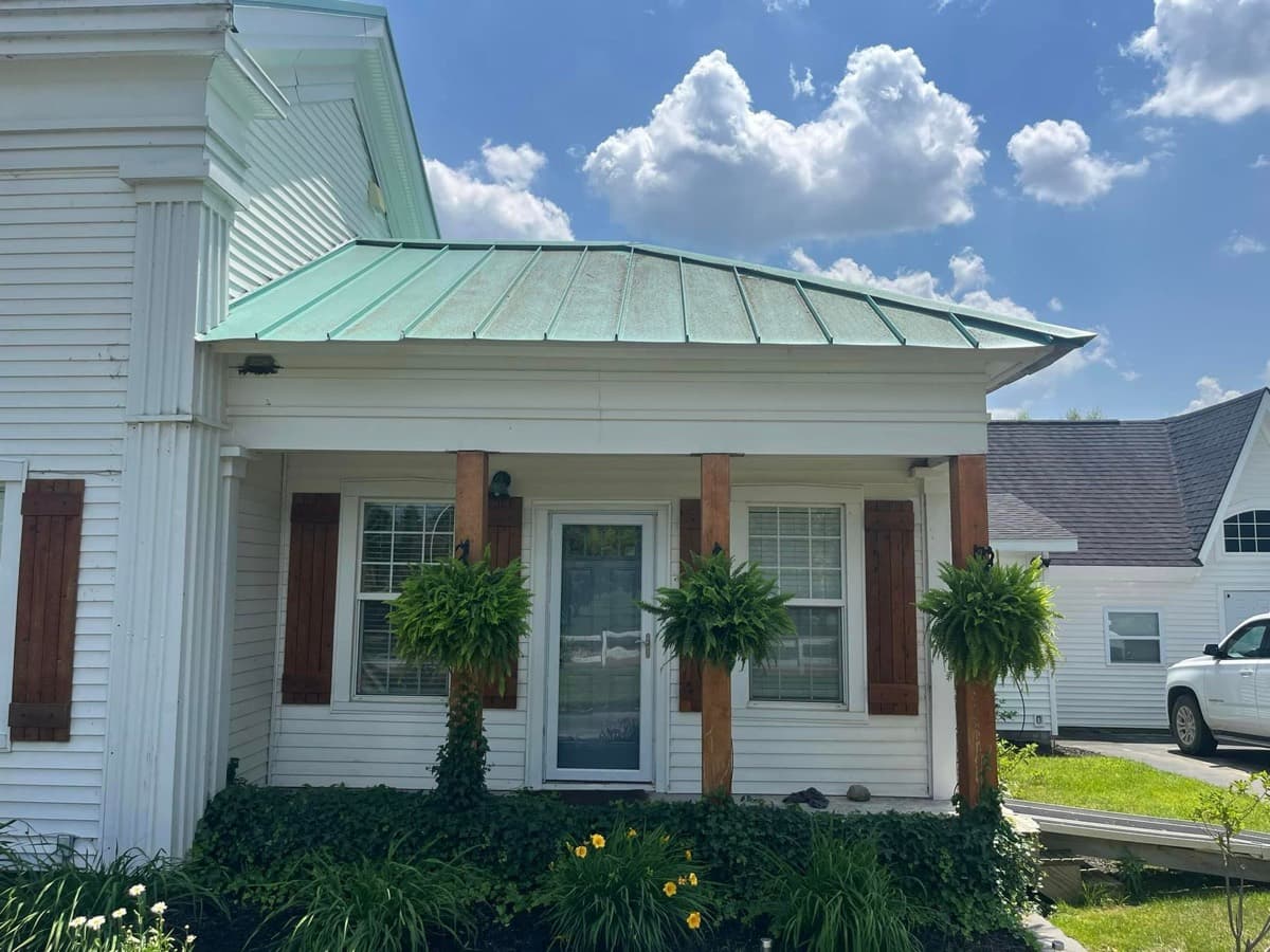 White farmhouse exterior dulled by dirt before washing