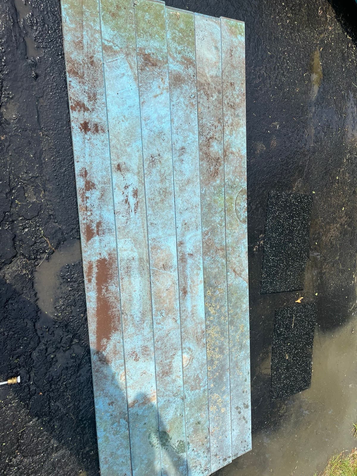 Blue picnic table covered in rust stains and grime before cleaning