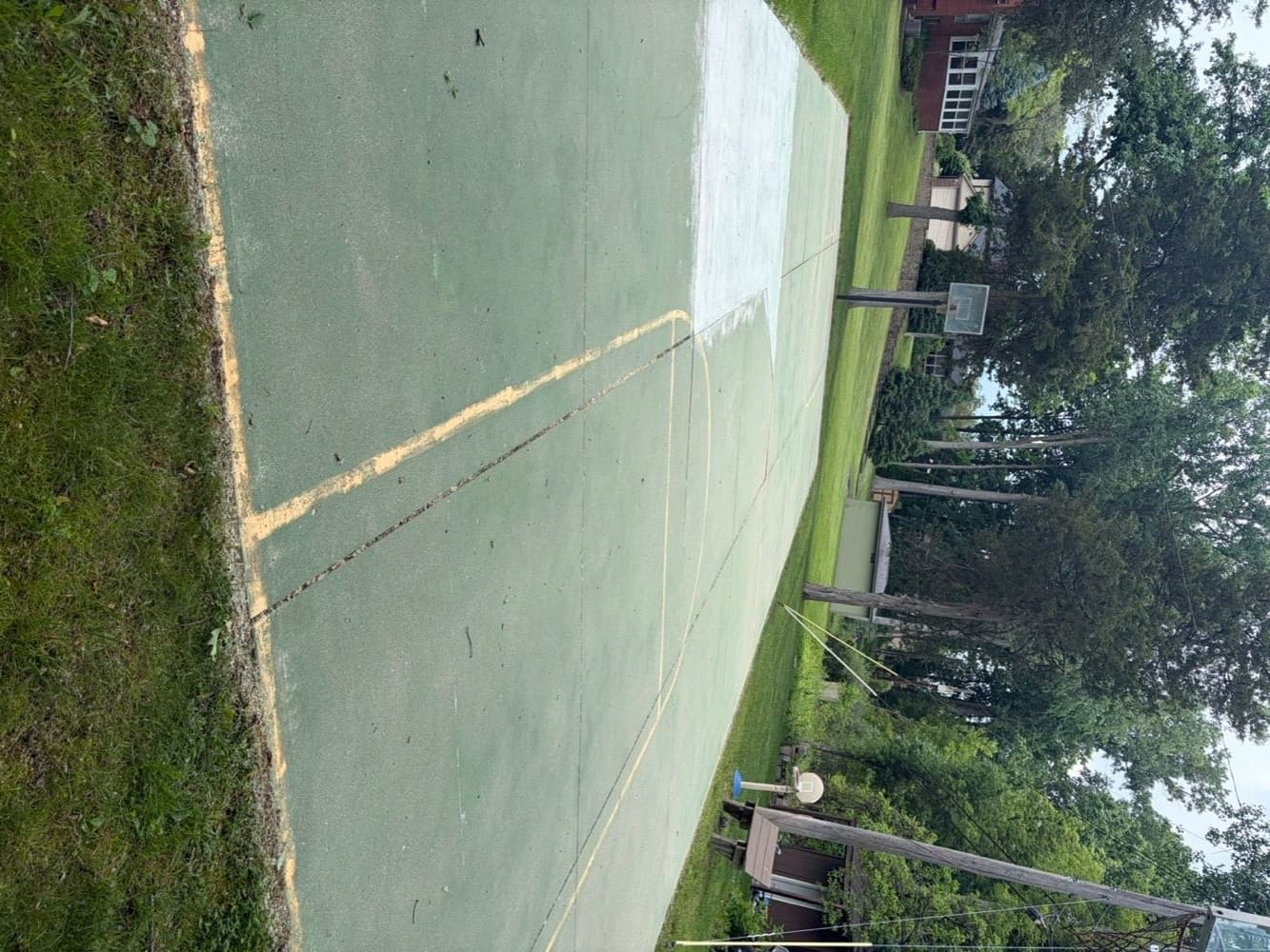 Sport court half cleaned showing the difference