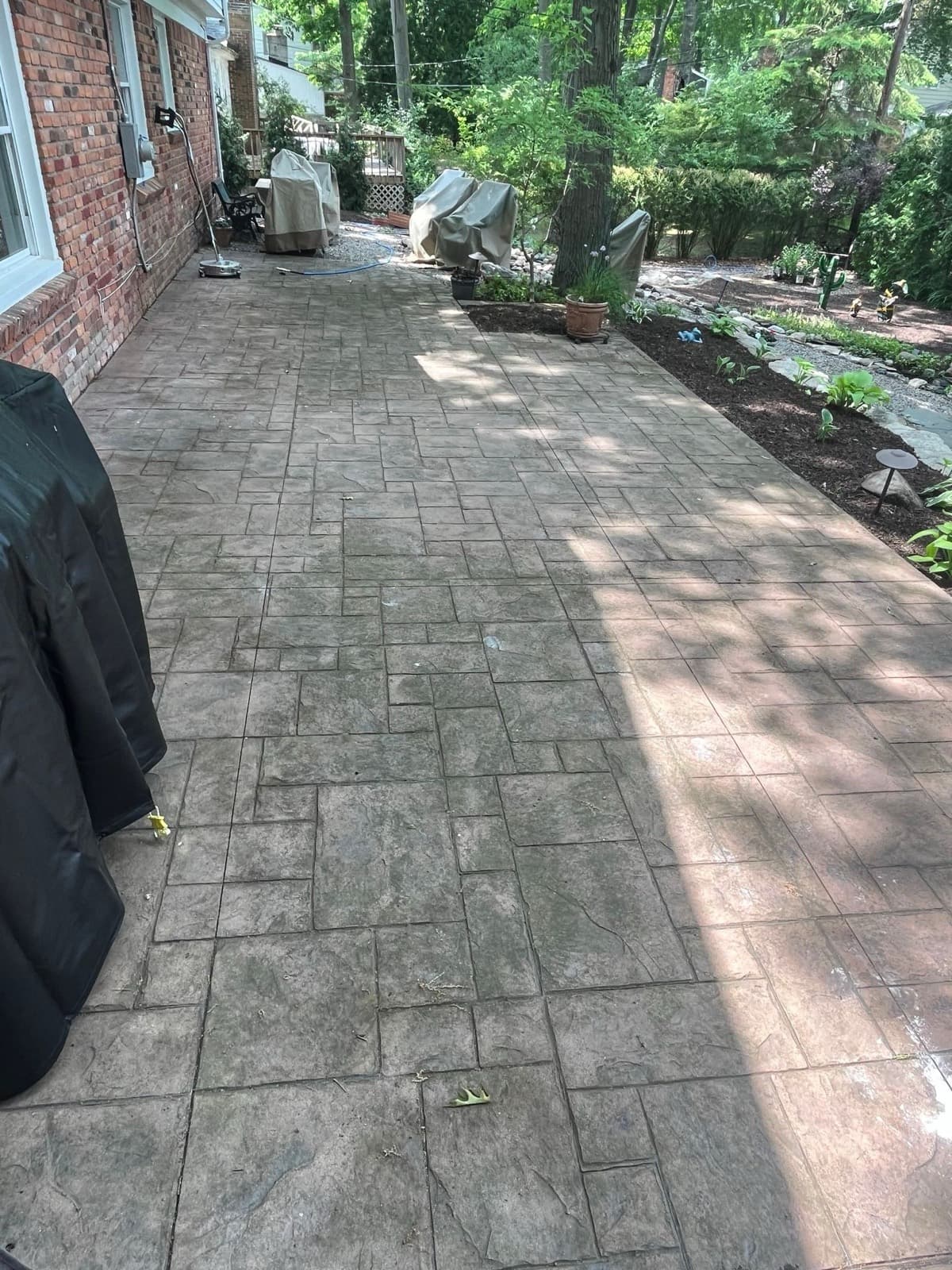 Stamped concrete patio faded and gray before cleaning and sealing