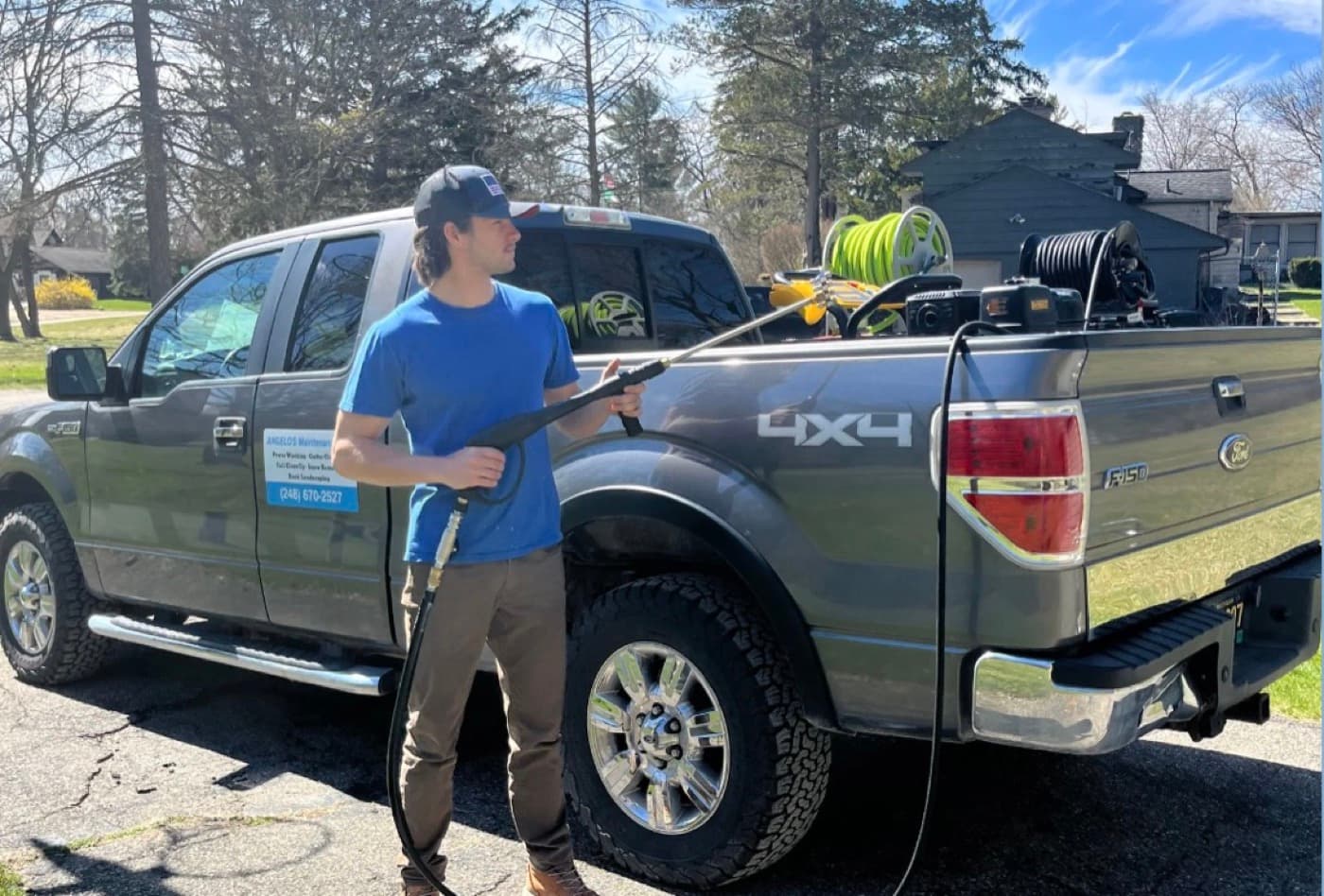 Angelo with his pressure washing rig and branded work truck in Bloomfield Hills